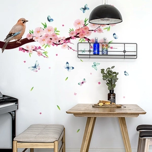 Detail showing bird and butterfly wall stickers on a branch in a living room setting