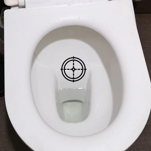 Waterproof target sticker for toilet training in black crosshair style on white ceramic