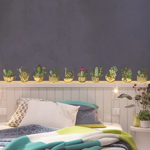 Detail of hand-painted cactus and succulent wall stickers on a dark gray bedroom wall