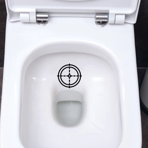 Macro shot of a black target decal applied on a clean white ceramic toilet bowl surface
