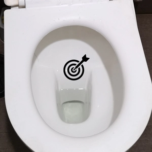 Detail view of funny target and arrow decals on a white toilet interior for better aiming