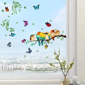 Detail view of colorful bird and butterfly static window decals on glass with city background