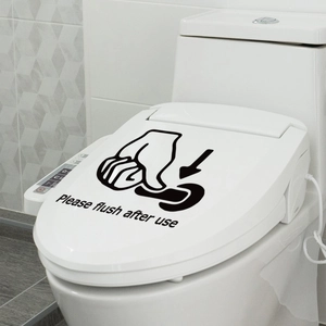 Detail of waterproof 'Please flush after use' sticker applied on a white toilet lid