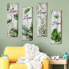 Close-up of four wooden tropical leaf wall plaques with Live Love Laugh Hope text