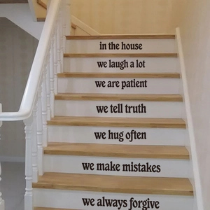 Detail of English family rules wall decals applied to white stair risers in a home