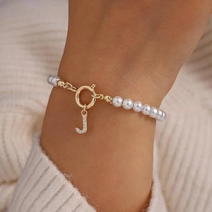 Parelarmband met gouden letter J hanger en fonkelende kristallen versieringen