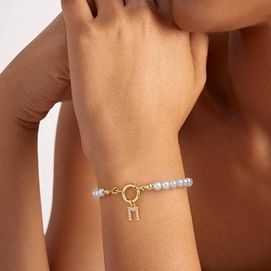 Elegante parelarmband met gouden letter M-hanger en schitterende zirkonia accenten