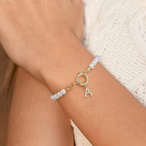 Barokke parelarmband met gouden OT-sluiting en diamanten letter A-hanger aan ketting