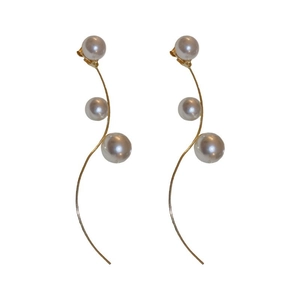 Elegant gold S-curve long earrings with three white pearls in a minimalist design