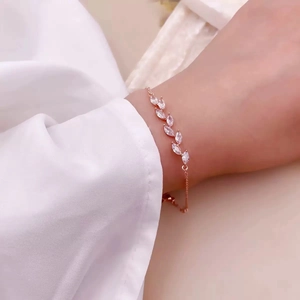 Détail du bracelet en or rose avec cristaux en forme de feuille sur poignet