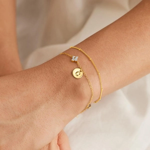 Elegant gold double-layered anklet featuring zircon flower charm and letter C pendant