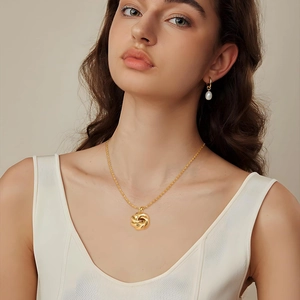 Elegante set collana con ciondolo intrecciato in oro 18k e orecchini con perle bianche