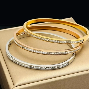 Polished titanium steel bangles set with cubic zirconia stones in gold and silver finish