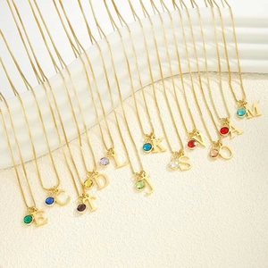 Collana con iniziali placcata oro 14K e pietre portafortuna su espositore bianco