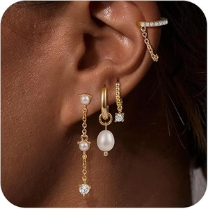 Set di orecchini in ottone placcato oro con zirconi e perle indossati da una modella