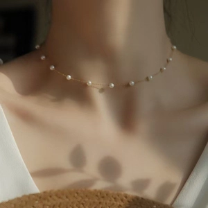Elegant gold choker necklace with delicate pearls and minimalist feminine aesthetic