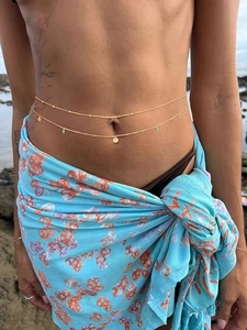 Close-up of bohemian double-layered gold waist chain with sequins and turquoise beads