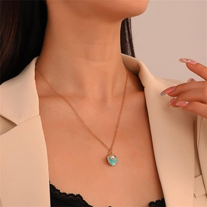 Elegante collar dorado con colgante de concha azul y un pequeño detalle de perla blanca