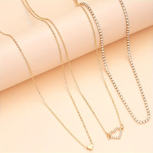 Ensemble de trois colliers dorés avec pendentifs cœur et chaîne tennis scintillante