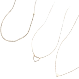 Ensemble de trois colliers dorés avec chaîne tennis et pendentifs cœur sur fond blanc
