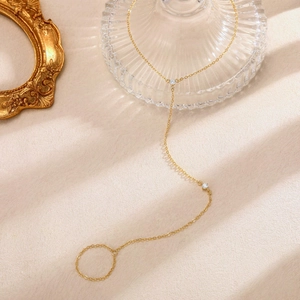 Elegante bracciale da dito dorato a strati con zirconi chiari e catenine minimaliste a sfere