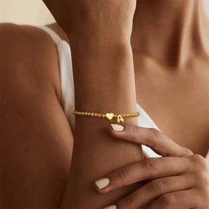 Goldenes Perlenarmband mit Herzanhänger und Buchstabe A für Damen am Handgelenk