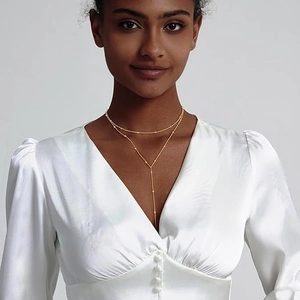 Collana a Y a doppio strato dorata minimalista da donna indossata da una modella elegante