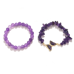 Close-up of purple natural stone bracelet set with golden crystal butterfly charm