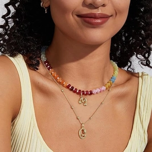Collana a due strati con perle multicolore e ciondoli a lettera M e C in metallo dorato