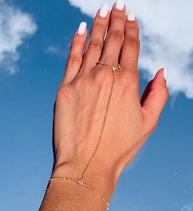 Macro shot of gold zircon slave bracelet featuring a ring-to-wrist delicate chain link