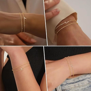 Double-layered gold chain bracelet set with CZ-inlaid initial pendants and bead chain