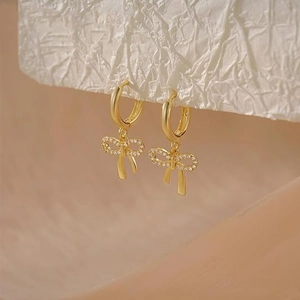 Detailansicht der eleganten Gold-Schleifen-Ohrringe mit funkelnden weißen Zirkonia