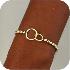 Golden beaded bracelet featuring stylish interlocking geometric rings on a female wrist