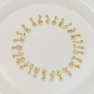 Set of 26 DIY bubble letter A-Z pendants in 18k gold plated copper on a white tray