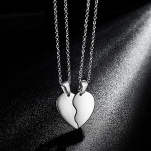 Polished stainless steel split heart pendant necklace set for couples on black background