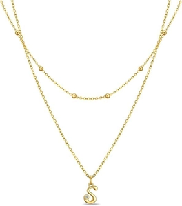 Detail of layered gold beaded necklace featuring a sparkling crystal and letter S pendant