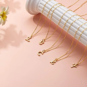 Gold layered beaded necklaces with rhinestone-encrusted LUCKY letter pendants