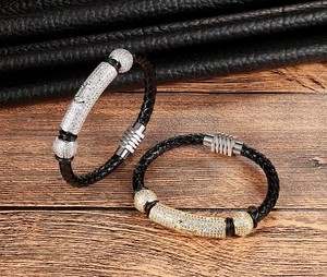 Detail of woven leather bracelets with anchor engraving and sparkling metal charms