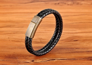 Detailed close-up of double-layer woven black leather bracelet with antique bronze clasp