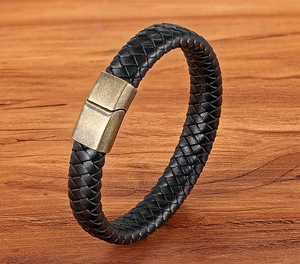 Detailed view of black braided leather bracelet with vintage gold magnetic metal clasp