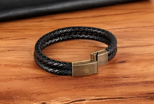 Detail of double-layer black braided leather bracelet with vintage bronze magnetic clasp
