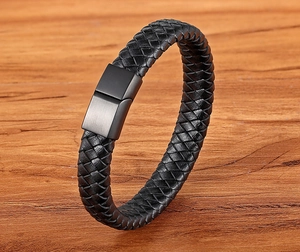Detail of black woven leather strap and brushed metal magnetic clasp on men's bracelet