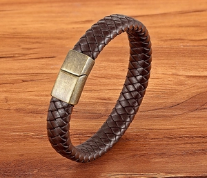 Detail view of woven brown leather bracelet with vintage brass magnetic metal clasp