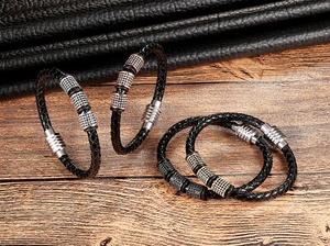 Macro-opname van gevlochten leren armbanden met micro-pave bedeltjes en metalen magneetsluiting