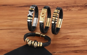 Detail of four woven leather bracelets for men with gold and silver polished metal charms