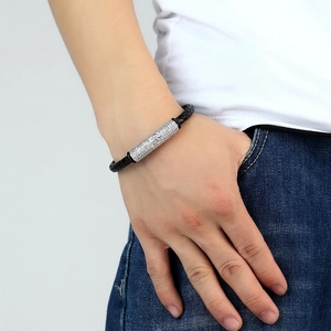 Braided black leather bracelet with silver zircon bead worn by a male model