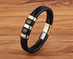 Detail of multi-strand braided black leather bracelet with gold magnetic clasp and steel beads