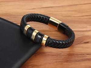 Macro shot of men's braided leather bracelet with black and gold polished metal rings