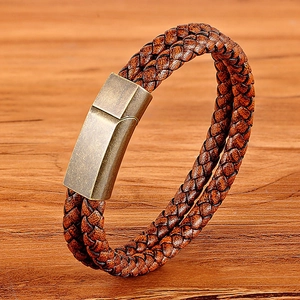 Punk brown braided leather bracelet with vintage bronze magnetic clasp on wooden desk