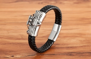 Detail of men's black braided leather bracelet with silver owl charm and magnetic clasp